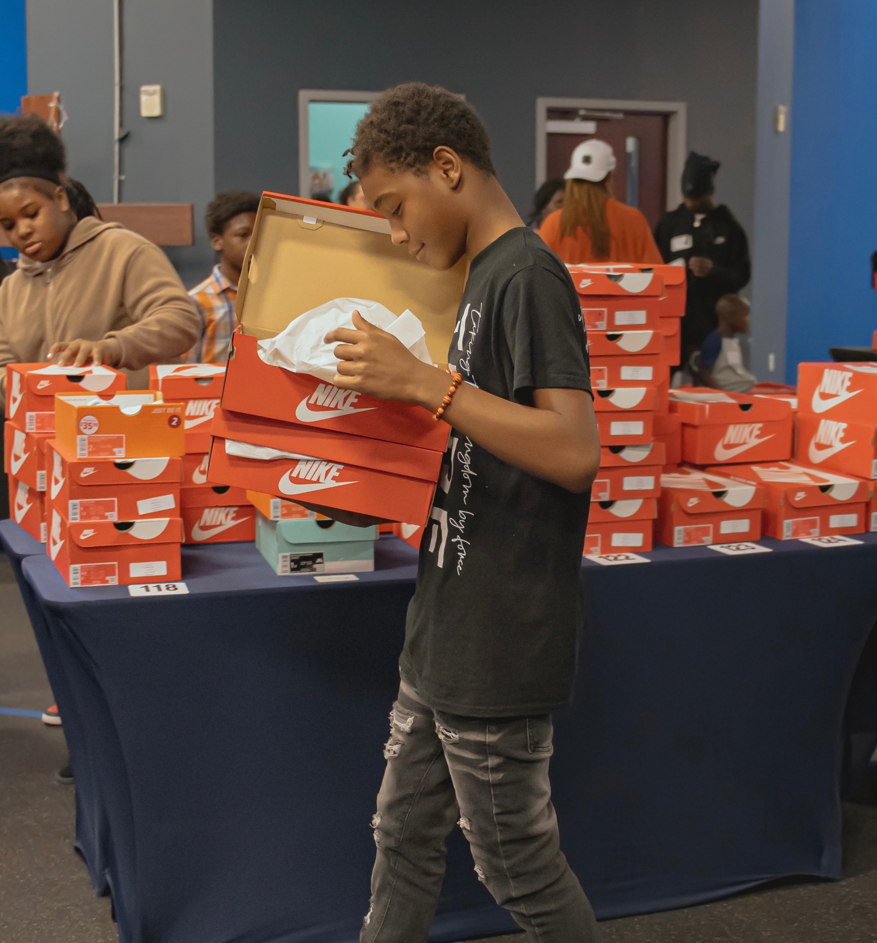 Volunteer carrying new Nike sneaker boxes